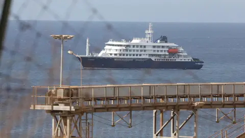 Imagen del MV Hondius PRAIA, May 6, 2026 -- The Dutch cruise ship MV Hondius is anchored off Praia, Cabo Verde, May 6, 2026. Cabo Verde on Wednesday carried out an air evacuation of three passengers suspected of hantavirus infection from the Dutch cruise ship MV Hondius, which had been anchored off the capital, Praia. The evacuation was conducted under strict security and health protocols, with personnel from the national police and public health services deployed from the Port of Praia to Nelson Mandela Int...