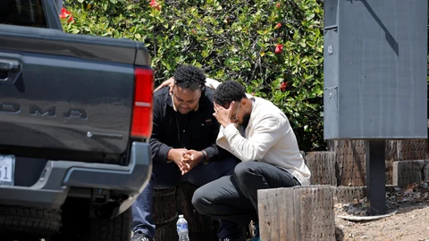 Dos hombres se consuelan mutuamente a las afueras de la mezquita atacada