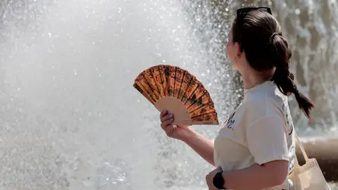 Una joven se abanica ante una fuente en el centro de la ciudad de València este viernes por el intenso calor. Una joven se abanica ante una fuente en el centro de la ciudad de València este viernes por el intenso calor.