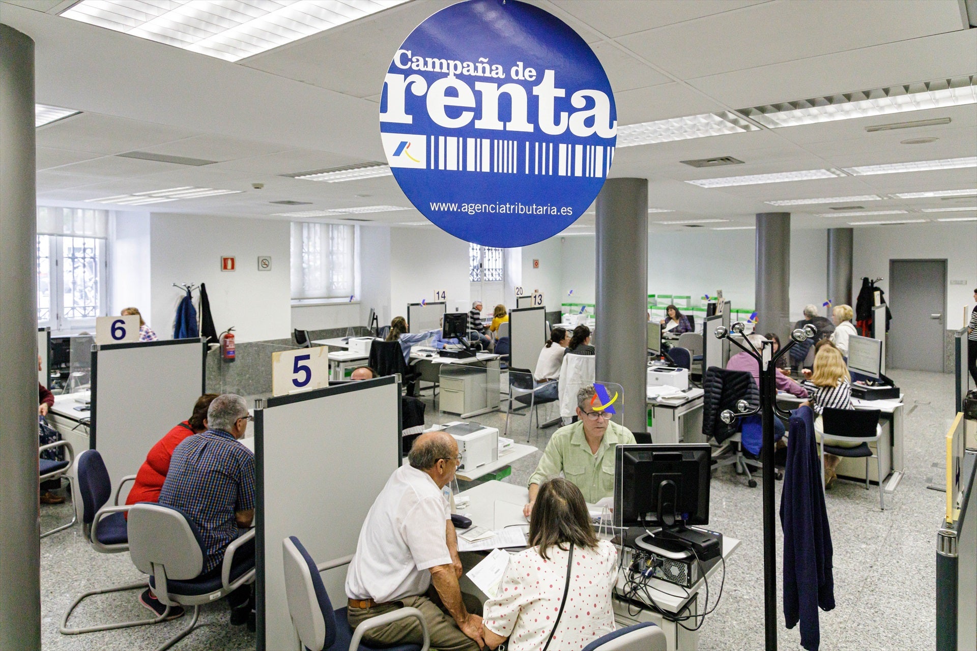 Varias personas son atendidas en la Agencia Tributaria para presentar la declaración de la renta en una fotografía de archivo. Varias personas son atendidas en la Agencia Tributaria para presentar la declaración de la renta en una fotografía de archivo.