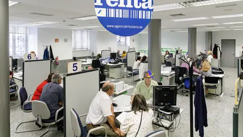 Varias personas son atendidas en la Agencia Tributaria para presentar la declaración de la renta en una fotografía de archivo. Varias personas son atendidas en la Agencia Tributaria para presentar la declaración de la renta en una fotografía de archivo.