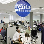 Varias personas son atendidas en la Agencia Tributaria para presentar la declaración de la renta en una fotografía de archivo. Varias personas son atendidas en la Agencia Tributaria para presentar la declaración de la renta en una fotografía de archivo.