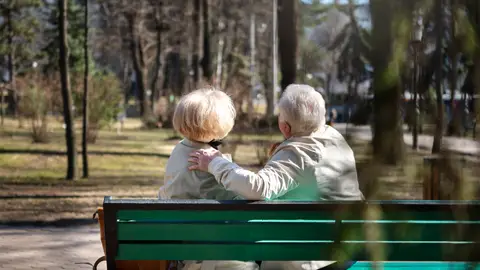 Dos personas mayores sentadas en un banco Dos personas mayores sentadas en un banco