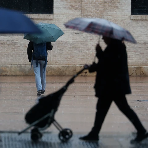 Varias personas con paraguas en un día lluvioso en València.