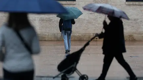 Varias personas con paraguas en un día lluvioso en València. Varias personas con paraguas en un día lluvioso en València.