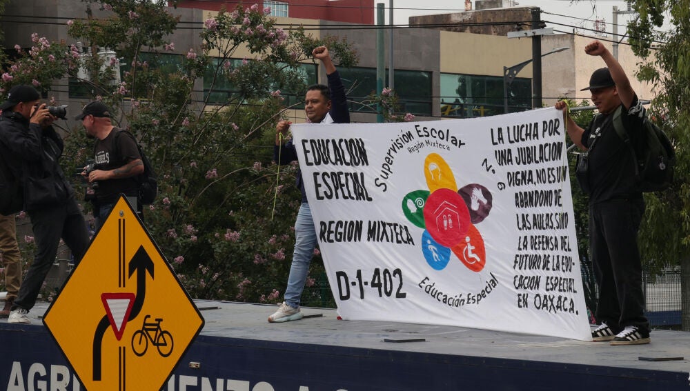 Varios manifestantes sostienen una pancarta con reivindicaciones