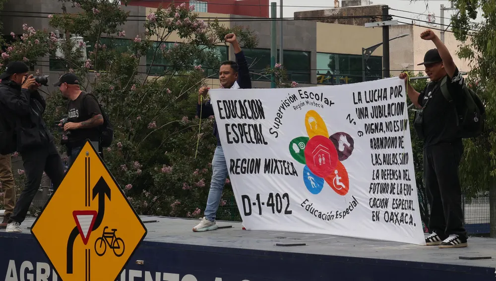 Varios manifestantes sostienen una pancarta con reivindicaciones Varios manifestantes sostienen una pancarta con reivindicaciones