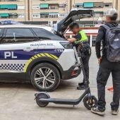 Un agente de la Policía Local de Elda y el propietario de un patinete eléctrico durante una inspección de ese vehículo.