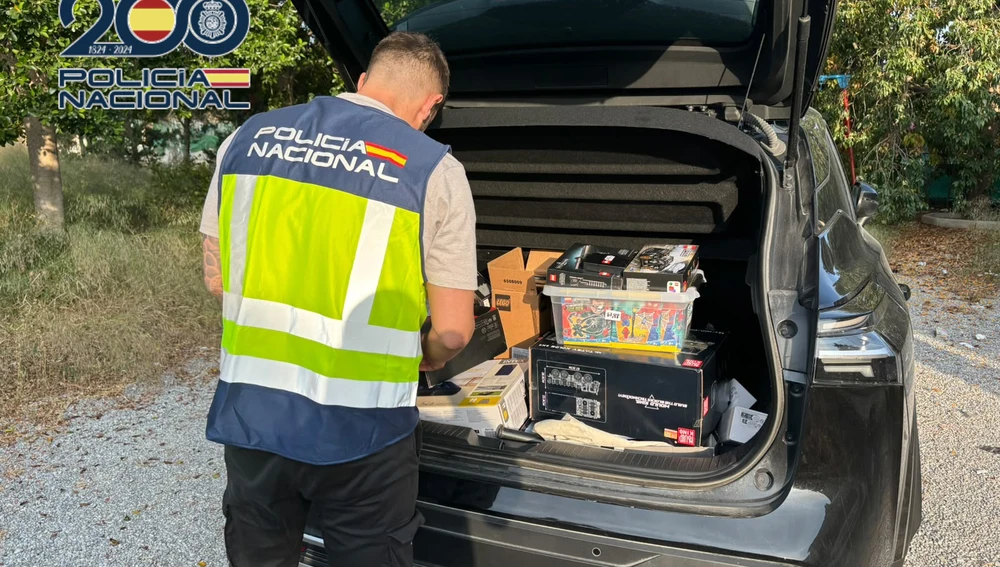Un agente de la Policía Nacional con algunos de los productos recuperados tras la detención practicada en Elche. Un agente de la Policía Nacional con algunos de los productos recuperados tras la detención practicada en Elche.