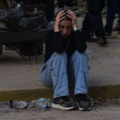 Una mujer permanece sentada a las afueras de un edifico afectado por un terremoto en la zona de Altamira en Caracas (Venezuela).