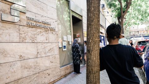 Varias personas migrantes esperan en el exterior de una oficina de la Seguridad Social, a 30 de junio de 2026, en Madrid (Espa&ntilde;a). 
