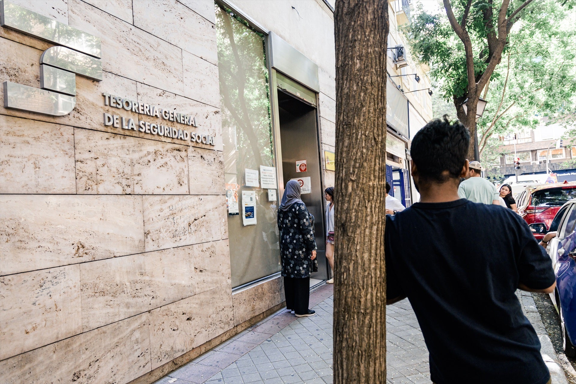 Varias personas migrantes esperan en el exterior de una oficina de la Seguridad Social, a 30 de junio de 2026, en Madrid (España). Varias personas migrantes esperan en el exterior de una oficina de la Seguridad Social, a 30 de junio de 2026, en Madrid (España).