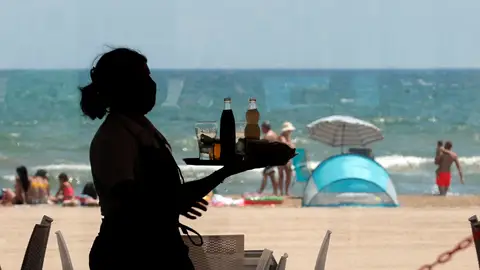 Una camarera lleva una bandeja con bebidas. Una camarera lleva una bandeja con bebidas.