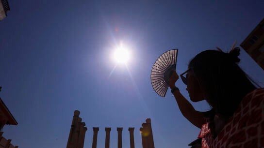 Imagen de este jueves de una viandante intentando protegerse del sol en C&oacute;rdoba