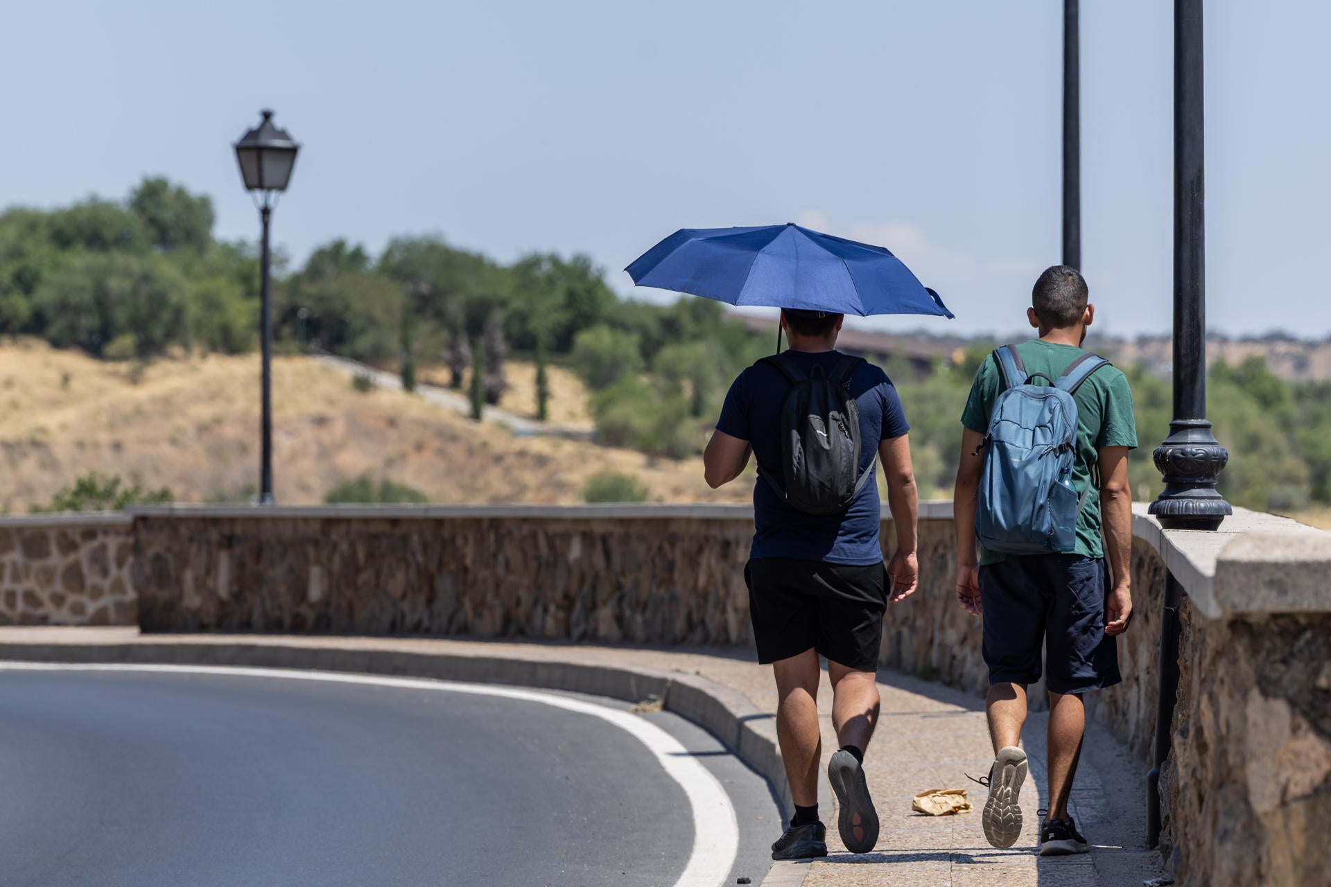 Una persona se protege del calor con un paraguas Una persona se protege del calor con un paraguas