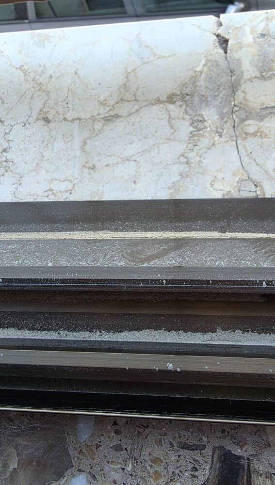 Polvo de arena acumulado en el rail de una ventana de una vivienda de la calle Blas Orts Sánchez.