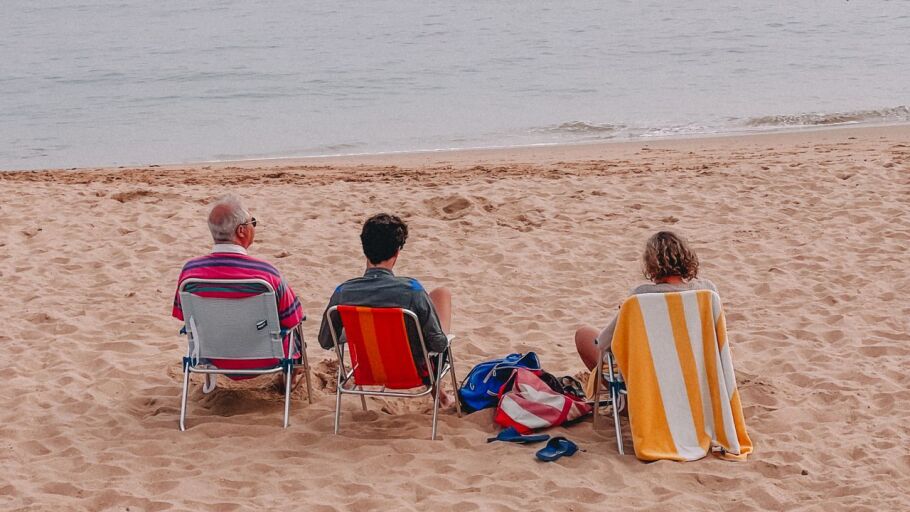 Un matrimonio descansa en la playa acompa&ntilde;ado de su hijo