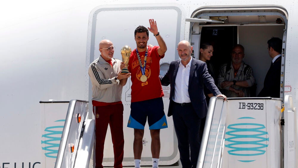 Rodri, Luis de la Fuente y Rafael Louzán llegan al aeropuerto de Barajas y ofrecen la copa del Mundo a la afición