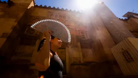 Una mujer se protege con un abanico para aliviar las altas temperaturas. Una mujer se protege con un abanico para aliviar las altas temperaturas./ EFE/Salas