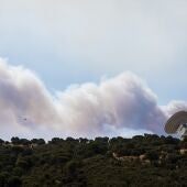 El humo de un fuego cercano sobrevuela una antena de la NASA, a 24 de julio de 2026, en Robledo de Chavela, Madrid (España).