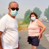 Vecinos de Navaluenga utilizan mascarillas para protegerse del humo del incendio de Burgohondo (Ávila). 