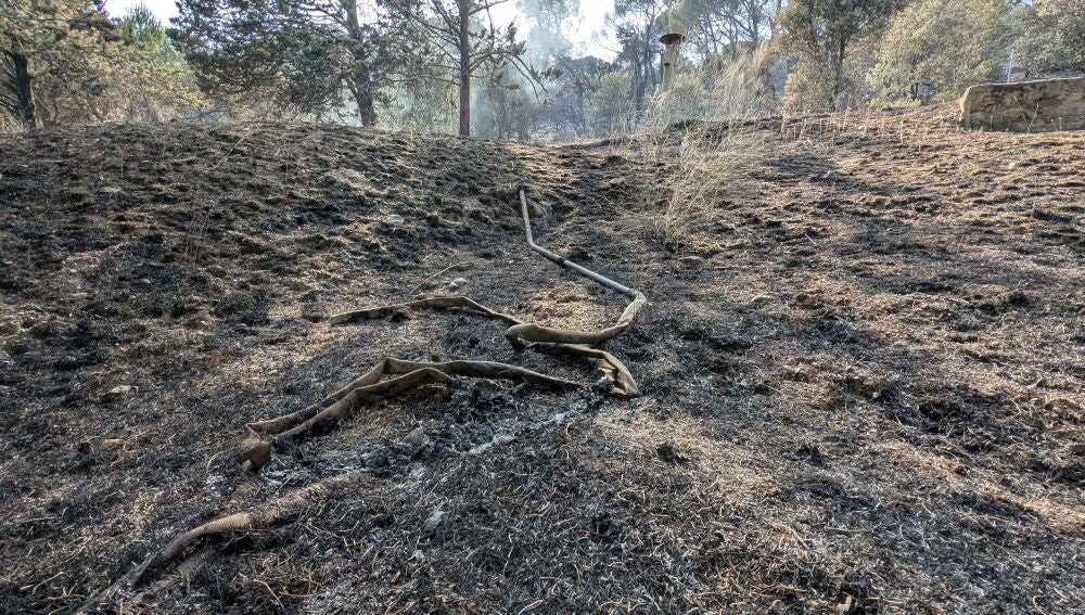 Una manguera de los operativos de emergencia afectada por las llamas