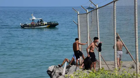 Varias personas cruzan la frontera, a 30 de julio de 2026, en Ceuta (España). Centenares de personas de origen magrebí han cruzado a lo largo de la mañana de hoy a Ceuta desde Marruecos, a nado y por el espigón, y una multitud está esperando al otro lado de la frontera para poder entrar en la ciudad autónoma de la misma manera. Varias personas cruzan la frontera, a 30 de julio de 2026, en Ceuta (España). Centenares de personas de origen magrebí han cruzado a lo largo de la mañana de hoy a Ceuta desde Marruecos, a nado y por el espigón, y una multitud está esperando al otro lado de la frontera para poder entrar en la ciudad autónoma de la misma manera.