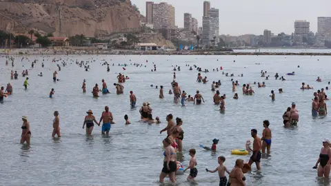 Imagen de archivo de varios bañistas en la playa de El Postiguet, en Alicante. Imagen de archivo de varios bañistas en la playa de El Postiguet, en Alicante.