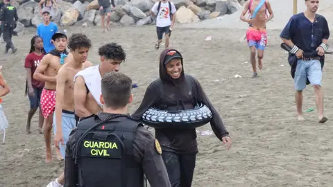 Un grupo de inmigrantes en la playa junto al paso fronterizo del Tarajal en Ceuta este viernes. Un grupo de inmigrantes en la playa junto al paso fronterizo del Tarajal en Ceuta este viernes.