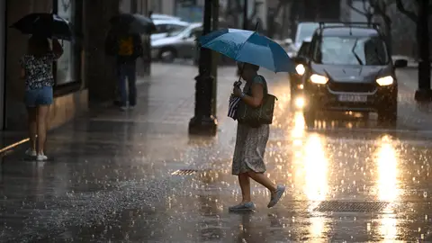 Una mujer cruza una calle de la ciudad de Castellón bajo una intensa lluvia.. Una mujer cruza una calle de la ciudad de Castellón bajo una intensa lluvia..