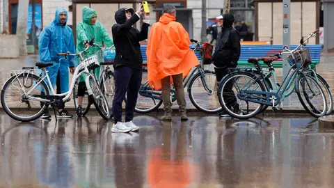 Varias personas se protegen de la lluvia con chubasqueros en València en un día de lluvia. Varias personas se protegen de la lluvia con chubasqueros en València en un día de lluvia.