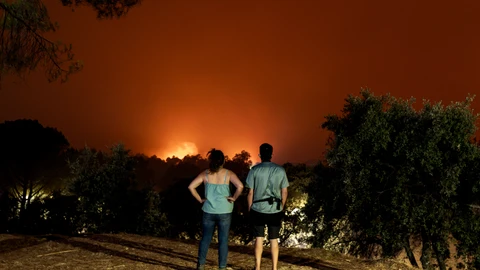 Dos personas presencian el incendio de Ávila desde La Adrada.