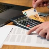 Folio impreso sobre una mesa junto a una calculadora