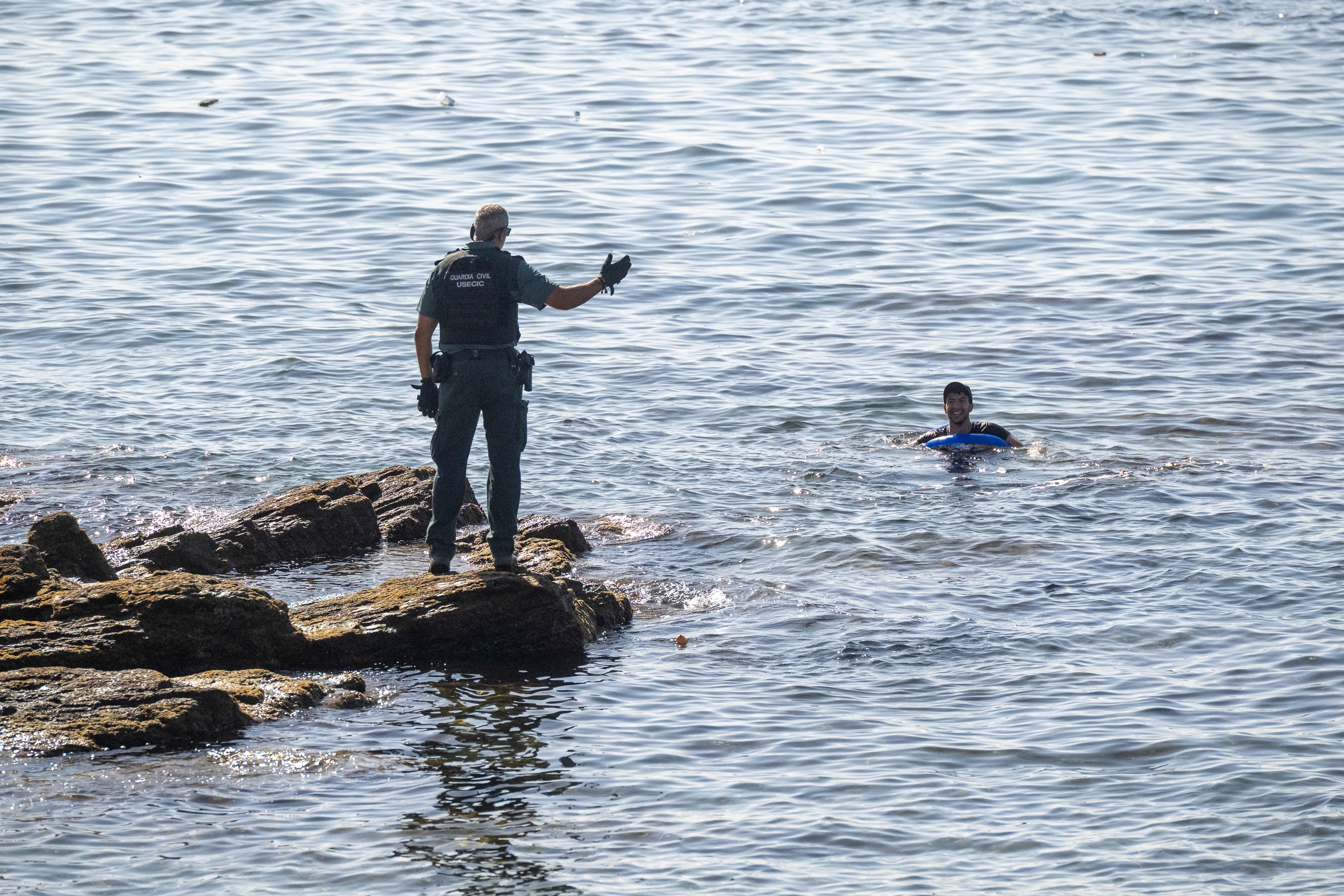 Un guardia civil avisa a una persona que nada en el mar Un guardia civil avisa a una persona que nada en el mar