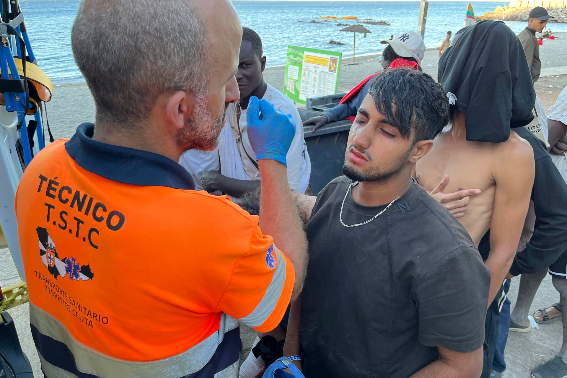 Imagen de archivo de un técnico de Cruz Roja de Ceuta realizando curas a personas migrantes en la playa del Trampolín Imagen de archivo de un técnico de Cruz Roja de Ceuta realizando curas a personas migrantes en la playa del Trampolín