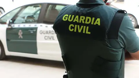 Un agente de la Guardia Civil, de espaldas, junto a un vehículo oficial. Un agente de la Guardia Civil, de espaldas, junto a un vehículo oficial.