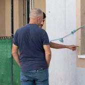 Dos personas ven los agujeros de bala en el lugar del crimen de Isla Cristina.