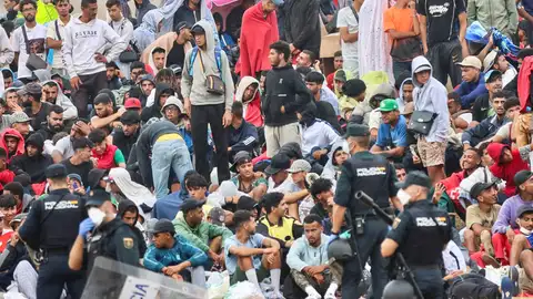 La policía vigila a inmigrantes que continúan viviendo en las inmediaciones de la playa del Trampolín en Ceuta, este viernes. La policía vigila a inmigrantes que continúan viviendo en las inmediaciones de la playa del Trampolín en Ceuta, este viernes.