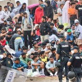 La policía vigila a inmigrantes que continúan viviendo en las inmediaciones de la playa del Trampolín en Ceuta, este viernes. 