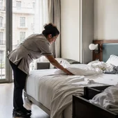 Una cambrera d'habitació d'hotel fent el servei després de la sortida dels hostes Una cambrera d'habitació d'hotel fent el servei després de la sortida dels hostes