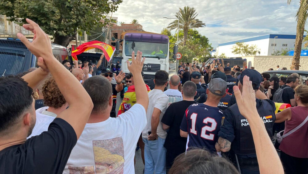 Ciudadanos impiden el acceso a miembros de Cruz Roja para entregar alimentos a los migrantes en la playa del Trampolín, este jueves en Ceuta.