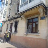 Una técnica del Concello entra, escoltada por la Policía Nacional, en el edificio incendiado en la Avenida de Hércules