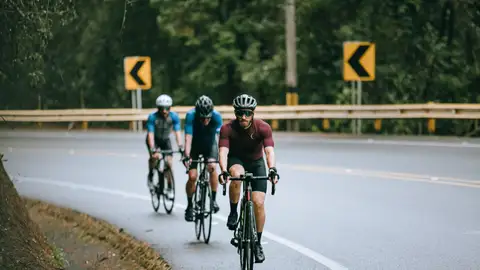 Tres ciclistas circulan por una carretera Tres ciclistas circulan por una carretera