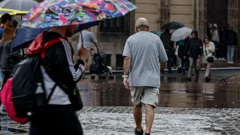 En la imagen, numerosas personas se protegen de la lluvia con paraguas mientras pasean por la plaza del Ayuntamiento de València. En la imagen, numerosas personas se protegen de la lluvia con paraguas mientras pasean por la plaza del Ayuntamiento de València.