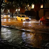 Coches circulan por una calle inundada tras las fuertes lluvias caídas en Valencia Coches circulan por una calle inundada tras las fuertes lluvias caídas en Valencia