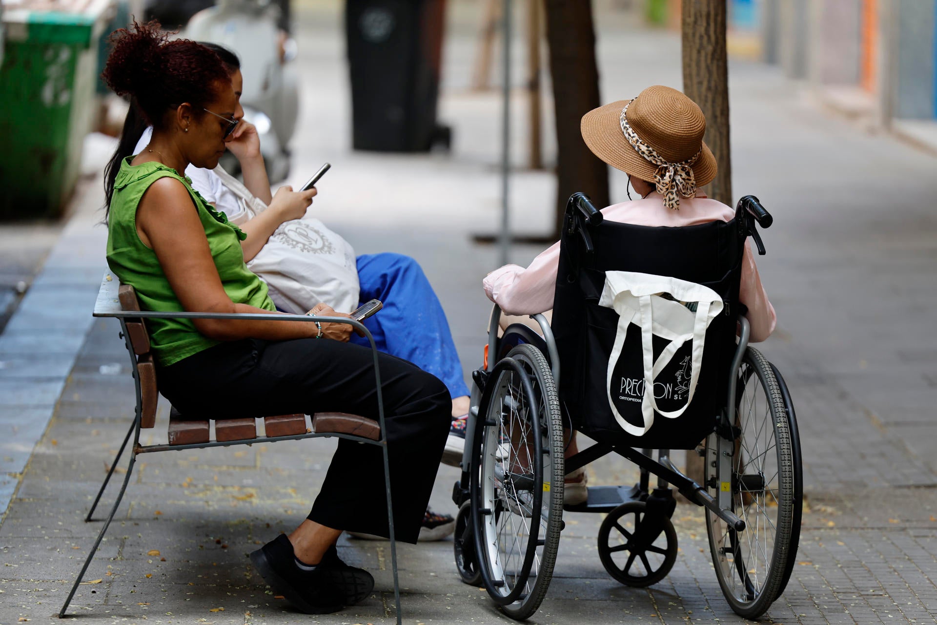Una mujer cuidadora con una persona mayor sentada en una silla de ruedas en una imagen de archivo. Una mujer cuidadora con una persona mayor sentada en una silla de ruedas en una imagen de archivo.
