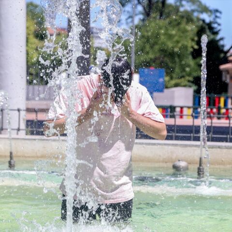 Una persona se refresca en una fuente