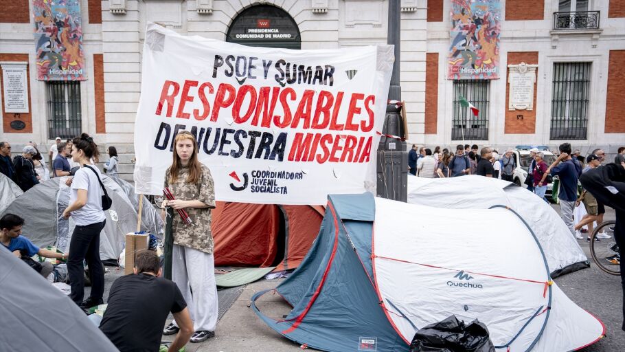 Numerosas personas con pancarta con lema 'PSOE y Sumar, responsables de nuestra miseria' se concentran en tiendas de campa&ntilde;a para exigir la aprobaci&oacute;n de un decreto sobre vivienda, en la Puerta del Sol, a 27 de septiembre de 2026, en Madrid (Espa&ntilde;a).