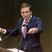 El alcalde José Luis Martínez Almeida sosteniendo un cartel que anuncia la manifestación por la vivienda.