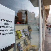 Detalle de un cartel avisando del cierre del comercio por la alerta roja por lluvias desde las 18 horas el interior norte y el litoral de Castellón y el litoral de Valencia